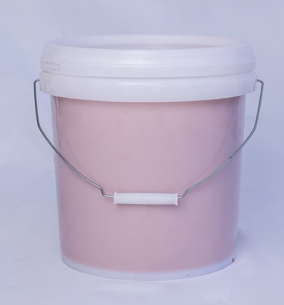 Seau de 10 kilos de pâte d’arachide naturelle sans additifs de couleur rose pâle.