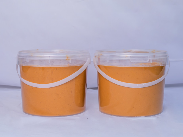 Deux seaux de 5 litres de pâte d'arachide 'Saveur d'Afrique' 100% naturelle, produite et transformée au Mali, sur un fond clair.