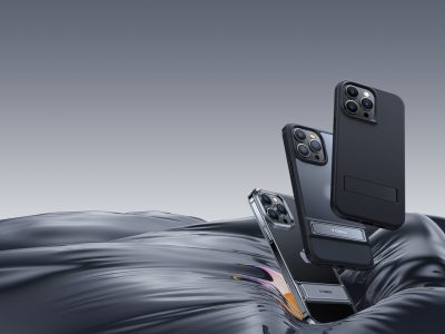 Trois coques de protection de téléphone Torras rebondissant sur une surface en tissu soyeux noir/gris foncé, avec un fond gris foncé plus clair.