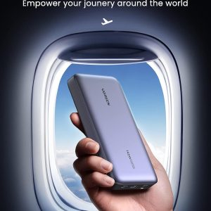 Power Bank 25000mAh, 145W – Ugreen tenue en main près d'une fenêtre d'avion, approuvée pour les voyages en avion.