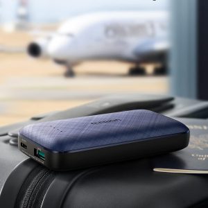 Batterie portable 10000mAh, 20W – Ugreen sur une valise avec un avion en arrière-plan.