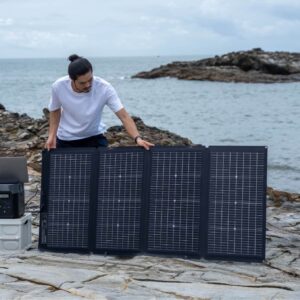 Homme utilisant le panneau solaire bifacial portable 220W EcoFlow près de la mer.