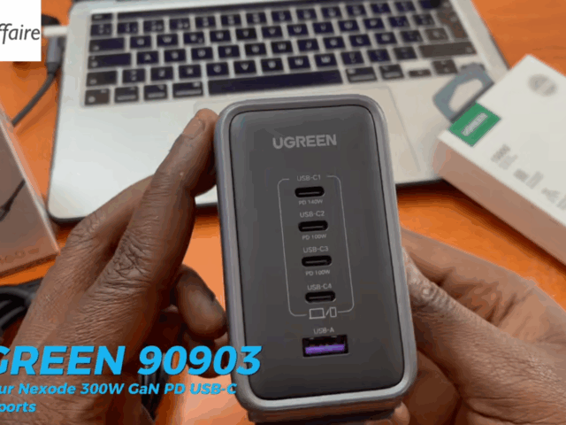 Chargeur UGREEN Nexode 300W avec ports USB-C et USB-A tenu en main devant un ordinateur portable.